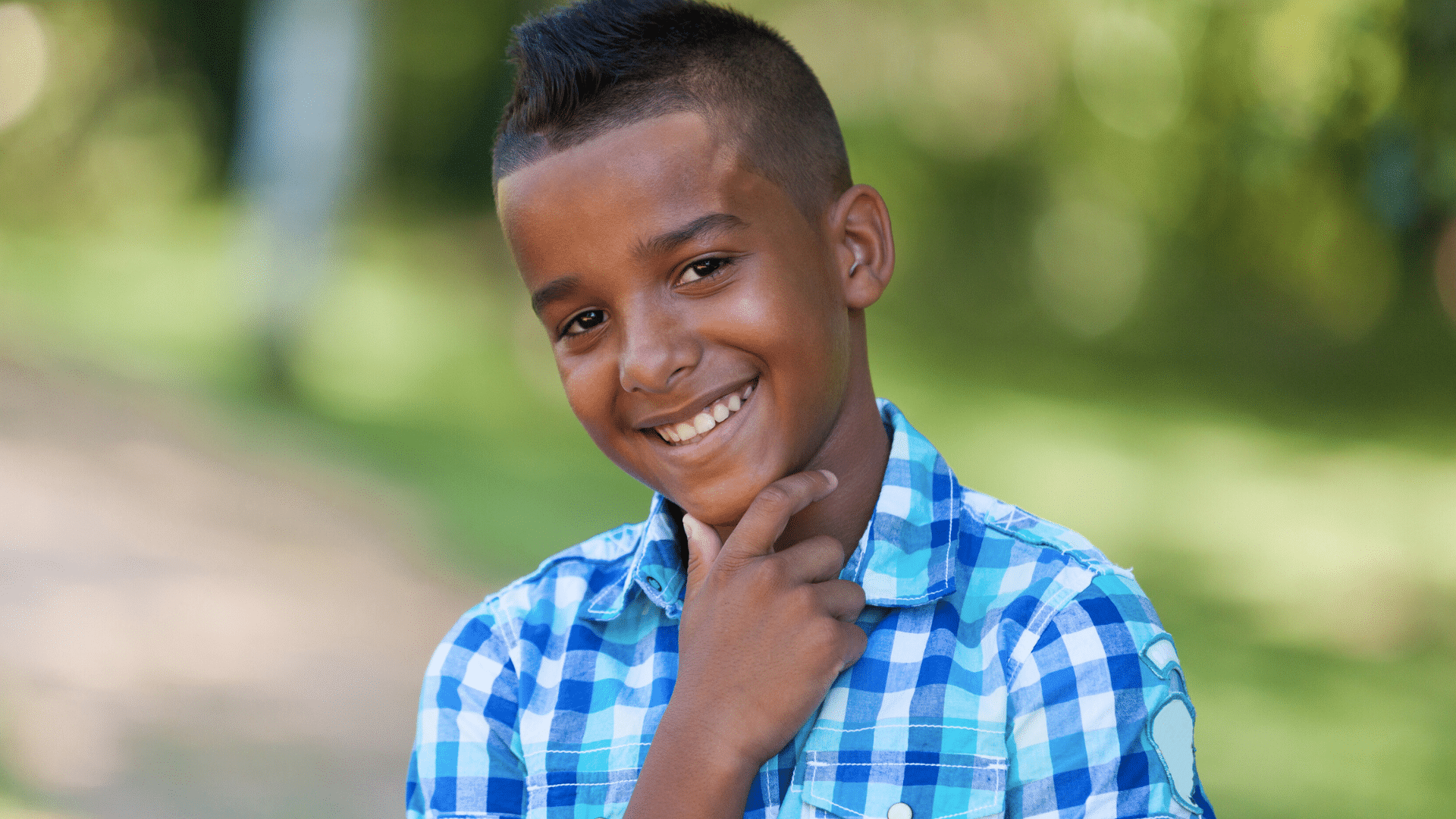 Smiling young boy outdoors for early orthodontic care at Bernhardt & Smith Orthodontics, Bishop Drive Office and 50th Street Office in West Des Moines, IA