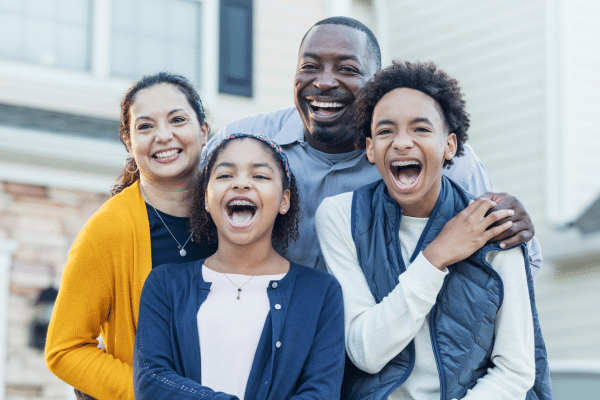 Smiling family outdoors for orthodontic financing and insurance options at Bernhardt & Smith Orthodontics, Bishop Drive Office and 50th Street Office in West Des Moines, IA