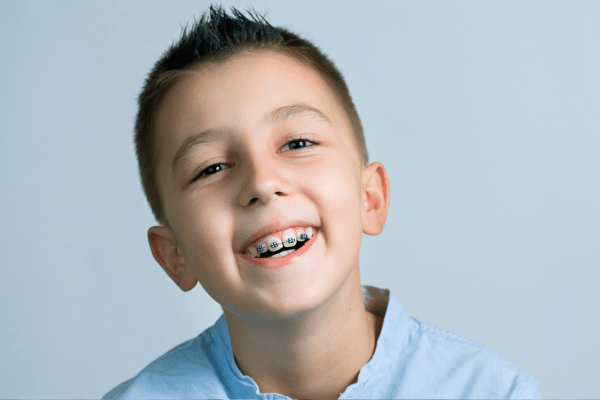 Smiling child wearing braces for early orthodontic treatment at Bernhardt & Smith Orthodontics, Bishop Drive Office and 50th Street Office in West Des Moines, IA
